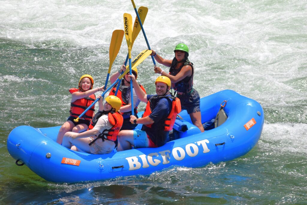 group of people putting their paddles in the air for a picture