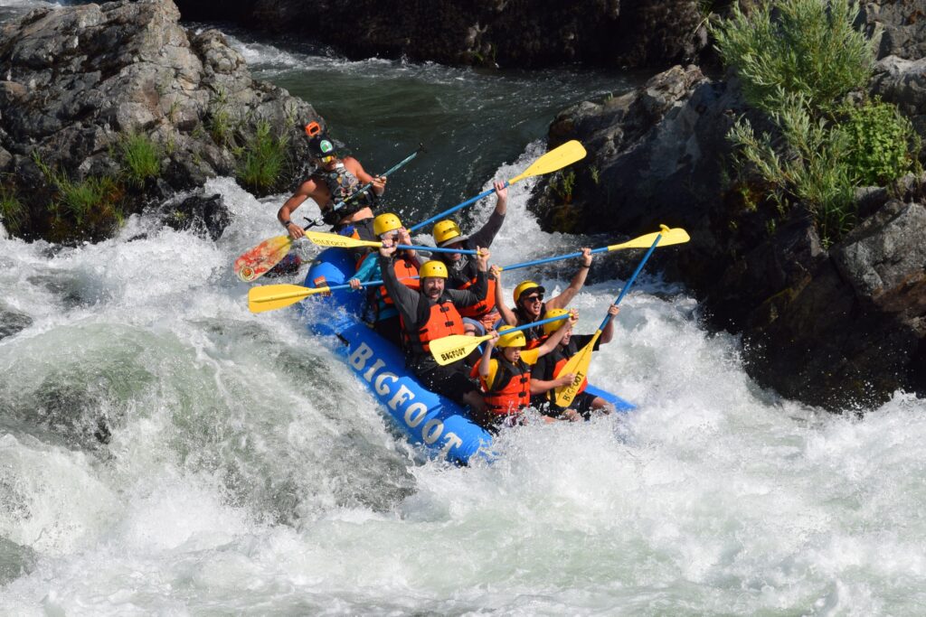 Rafters going down a small waterfall