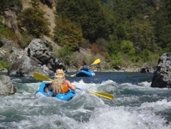 Two one person rafts on fast moving water